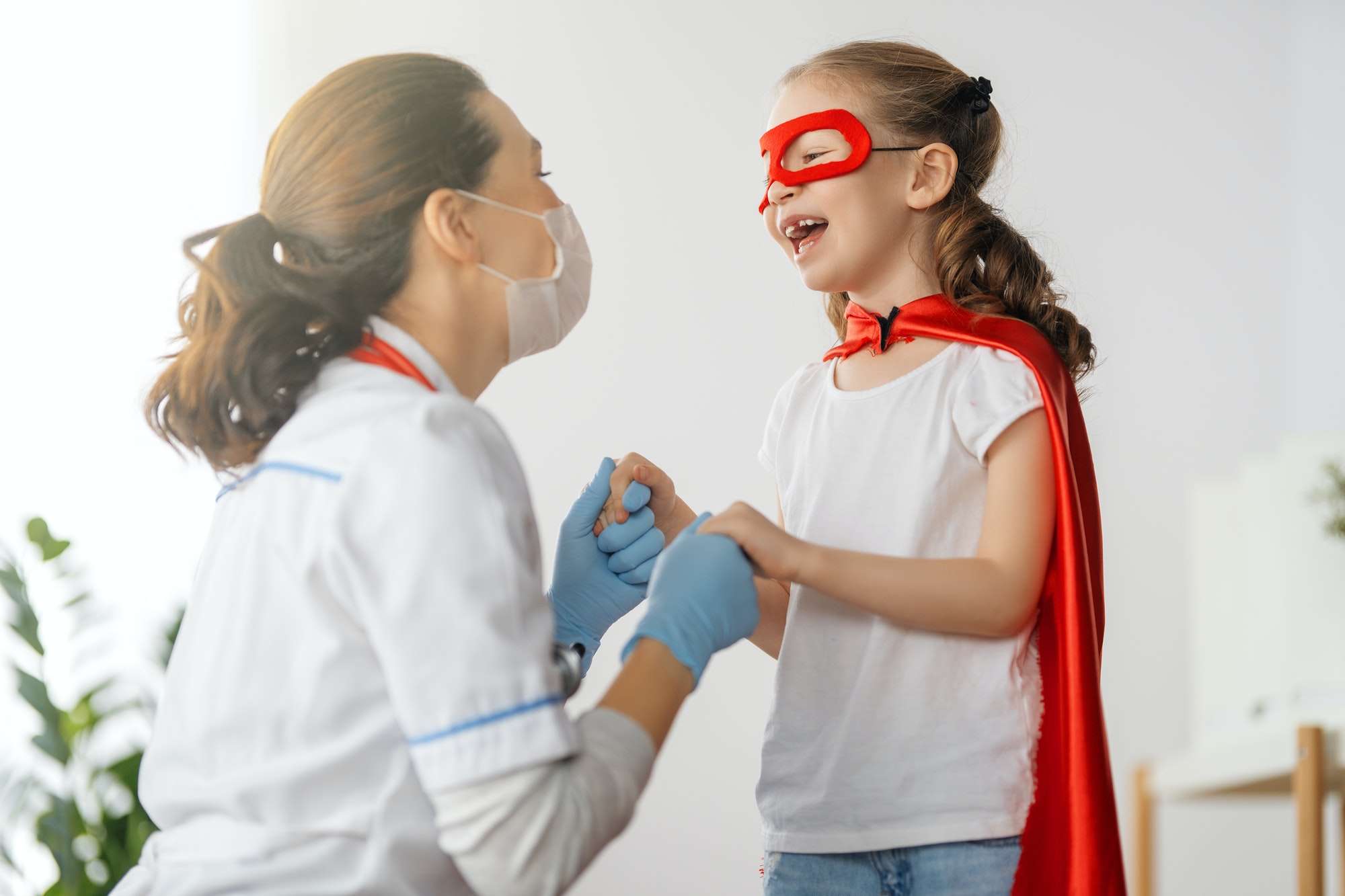 Doctor examining a young child, coordinating care that continues at home